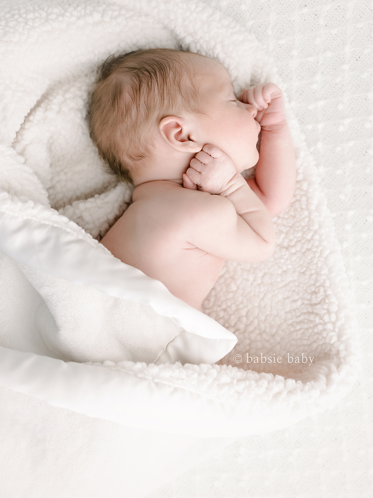 A photo of a baby girl in a natural sleeping pose.